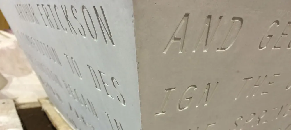 Serif lettering about Arthur Erickson cast crisply into two faces of a pale UHPC module