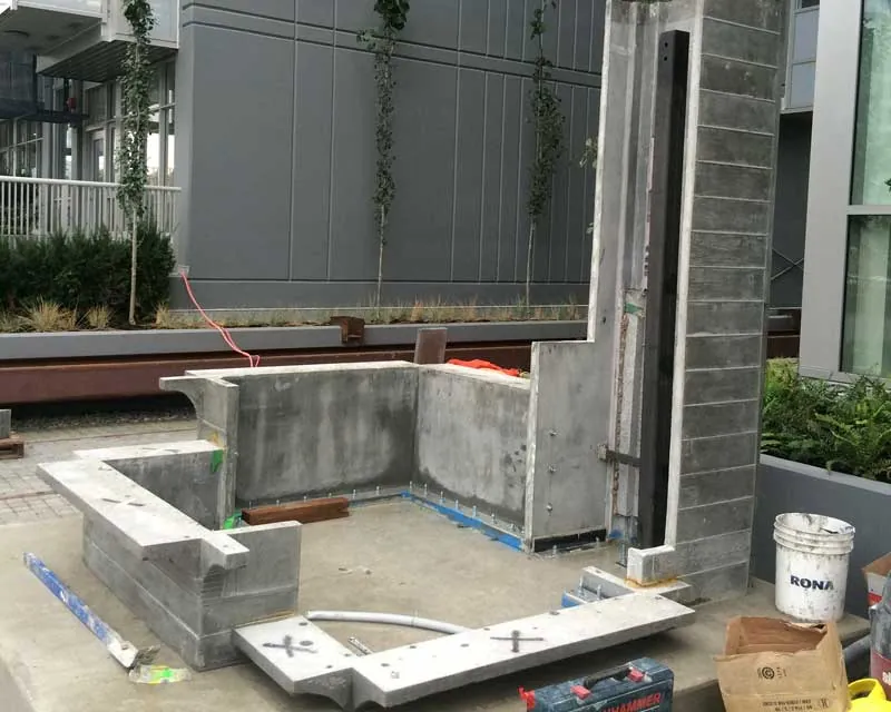 Board-formed UHPC panels of the Substation Pavilion mid-install at the Meccanica development
